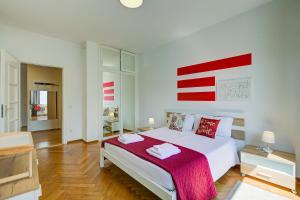 a white bedroom with a large bed with a red blanket at 76 The Lake House - Lugano in Melide