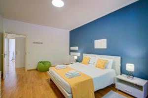 a bedroom with a large bed with a blue wall at 76 The Lake House - Lugano in Melide +151 photos