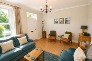 a living room with a blue couch and chairs at Brookfield Cottages in Bakewell