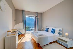a bedroom with a bed and a large window at 76 The Lake House - Lugano in Melide