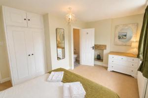 a bedroom with a bed and a bathroom with a sink at Brookfield Cottages in Bakewell +8 photos