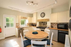 a kitchen with a wooden table and a dining room at Brookfield Cottages in Bakewell