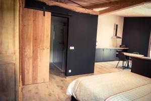 a bedroom with a bed and a table and a kitchen at Oh la vache in Stoumont