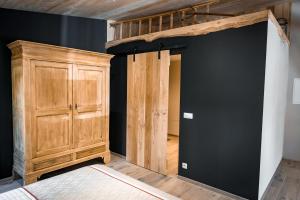 a bedroom with a bed and a wooden cabinet at Oh la vache in Stoumont
