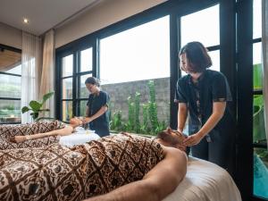 a couple of people getting a massage on a couch at Secana Beachtown Resort & Villas in Canggu