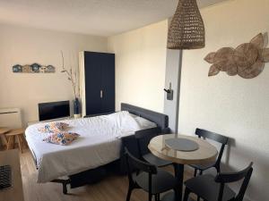 a bedroom with a bed and a table and chairs at La Mirande in Collioure