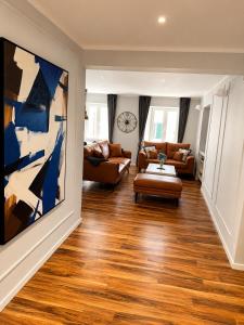 a living room with couches and a painting on the wall at Apartman Volosko in Opatija