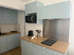 a kitchen with white cabinets and a wooden counter top at La Mirande in Collioure