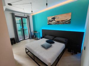 a bedroom with a bed with a blue wall at Manu & Manu Rooms in Garlenda