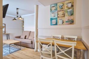 a living room with a table and chairs and a couch at Apartamentos Luna Suites Palacio Almagra in Granada