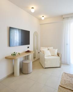 a living room with a couch and a tv on a wall at Maravel Star Art Hotel in Adelianos Kampos