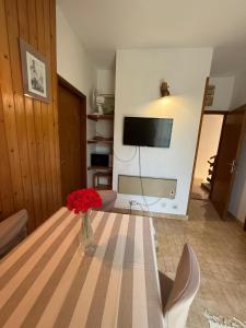 a living room with a table with a vase of red flowers at Green Quiet Apartments in Vodice