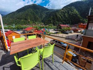 a wooden table and chairs on a balcony with a mountain at ADiLOGLU PANSiYON in Uzungöl