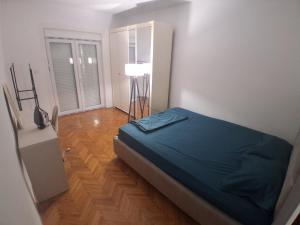 ein Schlafzimmer mit einem Bett, das mit einem blauen Laken bezogen ist in der Unterkunft Radoš in Igalo + 12 Fotos