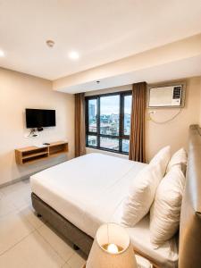 a hotel room with a bed and a television at Milton Hotel Makati in Manila