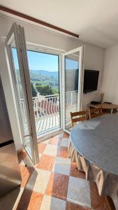a room with a table and a balcony with a view at Diving Apartments in Molunat
