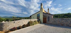 a small church with a stone wall at Agriturismo Gradec in Aurisina