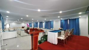 a large room with tables and chairs and blue curtains at Khemra Boutique in Kampot in Kampot