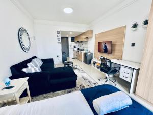 a room with a bed and a desk and a couch at Nyvin Haven at The Loftel in Ruaka