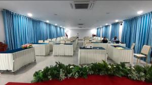 a large room with tables and chairs and blue curtains at Khemra Boutique in Kampot in Kampot +13 photos