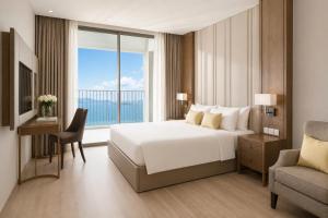 a bedroom with a bed and a desk and a window at HD Panorma Nha Trang Free Pool & Gym Condotel in Nha Trang