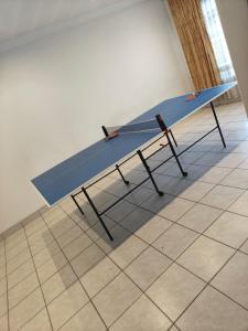 a blue ping pong table sitting on a tile floor at The Corner Lounge - Lenasia in Lenasia