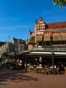 a group of tables and chairs in front of a building at Dam Residence Boutique Hotel Amsterdam - Zaandam in Zaandam