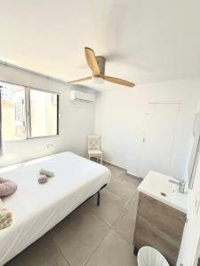 a bedroom with a bed and a ceiling fan at Cisne By Nest Hostel in San Antonio