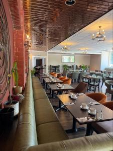 a restaurant with couches and tables and chairs at Inn On The Lake in Gravesend