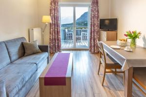 a living room with a couch and a table at Hölbinger Alm - Apartments in Anger