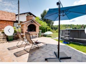 a patio with two chairs and an umbrella at Slavotova hiža in Mračin