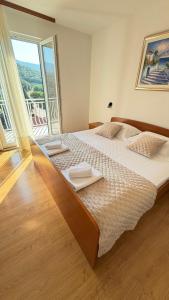 a bedroom with two beds and a large window at Diving Apartments in Molunat
