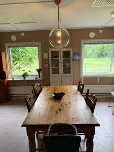 a dining room with a wooden table and chairs at Ängsstugan in Orkelljunga
