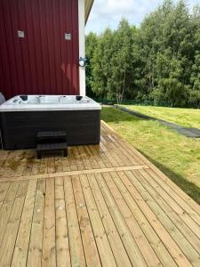 a hot tub sitting on a wooden deck at Ängsstugan in Orkelljunga