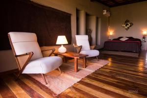 twee stoelen en een tafel in een kamer met een bed bij El Soberbio Lodge in El Soberbio