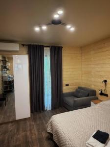 a bedroom with a bed and a couch in it at Joy WoodRest in Voropayev