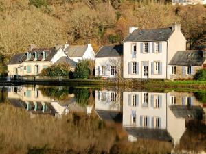 a group of houses next to a body of water at Gite Petite Florence in Châteauneuf-du-Faou