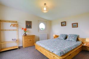 a bedroom with a bed and a dresser and a window at La Houle in Créances