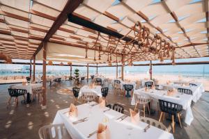 a restaurant with white tables and chairs and a view of the beach at Hurghada Long Beach Resort in Hurghada