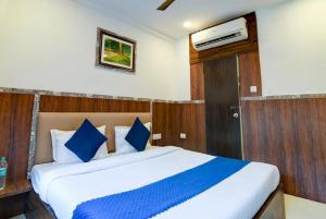 a bedroom with a large bed with blue pillows at Hotel Gareen By Du Rooms Near Delhi University Kamlangar in New Delhi +34 photos