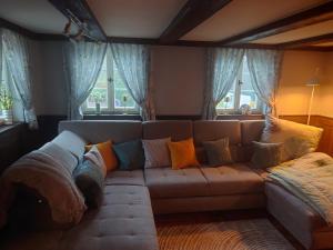 a living room with a couch with colorful pillows at Denkmal 1764 in Sasbachwalden