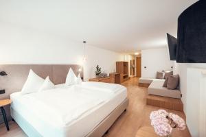 a bedroom with a large white bed and a couch at Ganis Resort in Nova Ponente