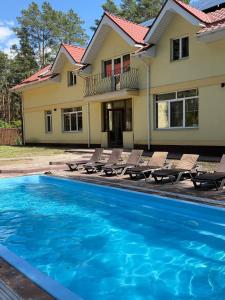 a house with a swimming pool in front of a house at Joy WoodRest in Voropayev