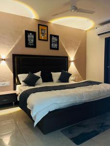 a bedroom with a large bed with four pillows at Wellawing Regency Samrala Chownk in Ludhiana