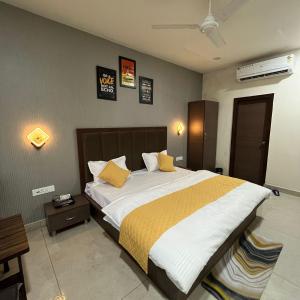 a bedroom with a large bed with yellow pillows at Wellawing Regency Samrala Chownk in Ludhiana