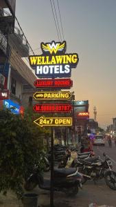 a group of motorcycles parked in front of a hotel sign at Wellawing Regency Samrala Chownk in Ludhiana