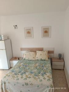 a bedroom with a bed with a floral bedspread at Atico Marin playa in Marín