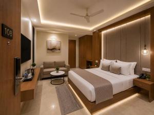 a hotel room with a large bed and a couch at Hotel Luxe Elite IGI Delhi in New Delhi +19 photos