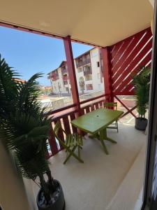 a balcony with a green table and potted plants at Appartement HOSSEGOR plage SUD Classé 3 étoiles in Soorts-Hossegor