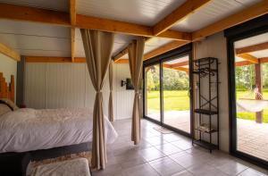 a bedroom with a bed and sliding glass doors at Aux étangs in Brutelles +31 photos